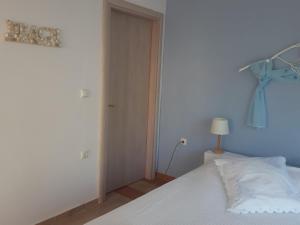 a bedroom with a white bed and a blue wall at Palio Villa in Paleo Tsifliki
