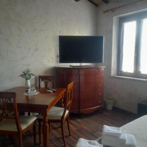 a dining room with a table and a large television at Casale della rosa in Loreto