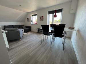 salon ze stołem, krzesłami i kanapą w obiekcie Hyggelig lejlighed w mieście Bindslev