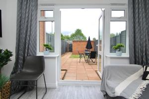 a bedroom with a bed and a sliding glass door at Dashing 2Bed Haven - Near Coventry Centre, Free Parking in Coventry