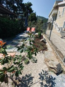 a garden with two red chairs and a house at Palio Villa in Paleo Tsifliki