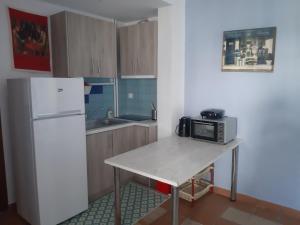 a kitchen with a table with a microwave and a refrigerator at Palio Villa in Paleo Tsifliki