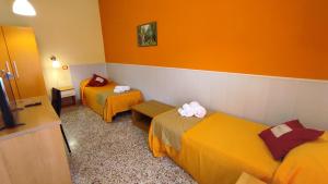 una camera d'albergo con due letti e una televisione di Abacus a Reggio di Calabria