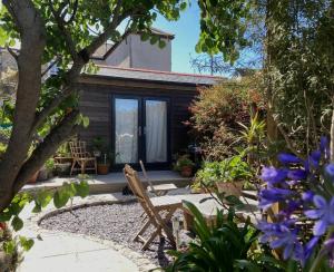 a garden with a bench and some flowers at The Little Studio in Penzance