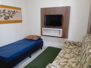 a room with a bed and a couch and a tv at Caldas Novas Lacqua Di Roma IV - 2 banheiros e cozinha, piscina 24 horas in Caldas Novas