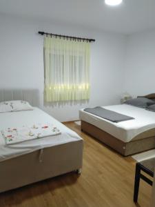 sypialnia z 2 łóżkami i oknem w obiekcie Bosnian Hobbiton w mieście Kovačevo Polje