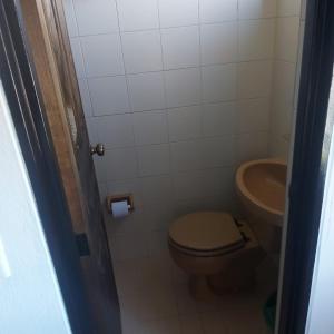 a small bathroom with a toilet and a sink at Casa Hotel León in Arbeláez