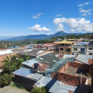 a city with roofs and mountains in the background at Casa Hotel León in Arbeláez