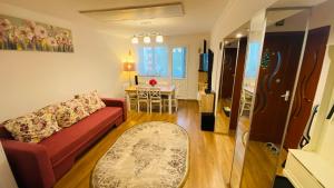 - un salon avec un canapé rouge et une table dans l'établissement Oli's Mountain Apartment, à Buşteni