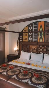 a bedroom with a large bed with a wooden headboard at Bamboo Garden Hotel in Serekunda