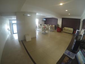 un vestíbulo con una sala de espera con mesas y sillas en Horizonte Hotel, en Mar del Plata