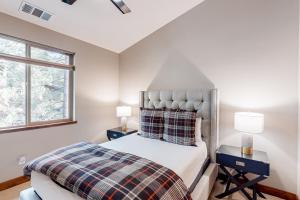 a bedroom with a bed with two night stands and two windows at Luxury Escape at Thunderbird in South Lake Tahoe