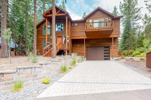 a wooden house with a garage in the woods at Luxury Escape at Thunderbird in South Lake Tahoe