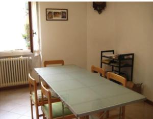 uma sala de jantar com uma mesa e cadeiras e uma janela em camera in via Tolstoi em Milão