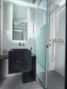 a bathroom with a glass shower and a sink at Nautilux Rethymno by Mage Hotels in Rethymno