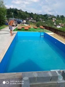 Un homme nettoie une piscine bleue dans l'établissement Крокус Мія, à Slavsko