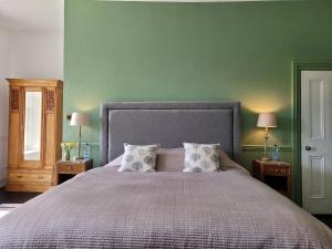 1 dormitorio con 1 cama grande y 2 mesitas de noche en The Old Vicarage en Kington