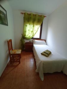 1 dormitorio con 2 camas, silla y ventana en Casa Yaya Felisa, en Lledó