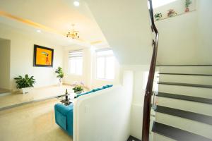 大叻的住宿－Asagari Dalat，客厅设有蓝色的沙发和楼梯。