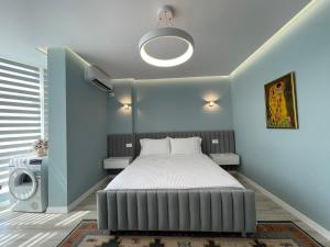 een slaapkamer met een bed en een blauwe muur bij Comfort Apartment In City Center in Tirana