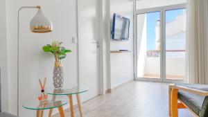 a living room with a glass table and a tv at Magnífico apartamento a 35m da praia - Apart. Isa in Albufeira