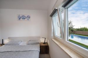Linardići的住宿－Apartmani Villa Ruby，一间卧室设有两张床和大窗户