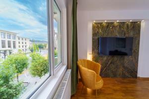 a living room with a large window with a tv at Main square 5 star luxury apartment with view in Cluj-Napoca