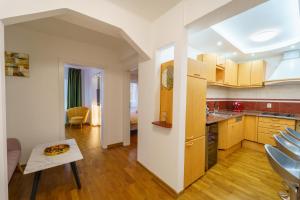 een keuken en een woonkamer met een tafel in een kamer bij Main square 5 star luxury apartment with view in Cluj-Napoca