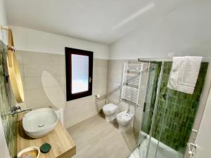 uma casa de banho com um WC e uma cabina de duche em vidro. em Il Timone B&B em Buggerru