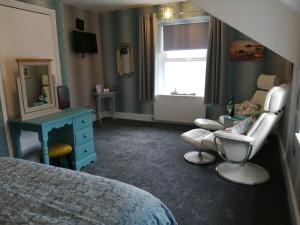 een slaapkamer met een baby in een stoel en een spiegel bij Craig-y-Mor in Criccieth