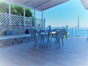 a table and chairs on a patio with a view of the ocean at Residenza Jonica in Letojanni