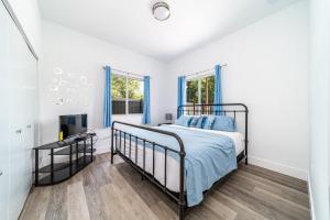 Un dormitorio con una cama y un televisor. en Pool Boutique Villa by the Beach 1, en Hallandale Beach