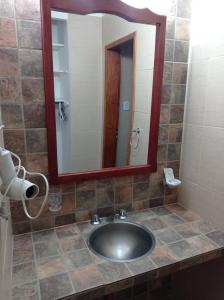 a bathroom with a sink and a mirror at LA CALLEJA Apart ,Departamento Con vista al Jardin in Olavarría