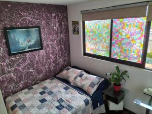 um quarto com uma cama e uma janela em The Mexican Spot/ 15 min. from Condesa em Cidade do México