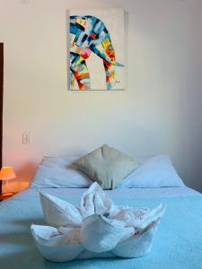 uma toalha numa cama com um quadro na parede em Pousada Arraial Caribe em Arraial do Cabo