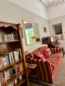 uma sala de estar com um sofá e prateleiras de livros cheias de livros em Beautiful Double Room in Idyllic West End Townhouse em Glasgow