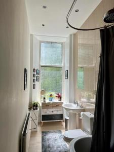 a bathroom with a tub toilet and a sink at Beautiful Double Room in Idyllic West End Townhouse in Glasgow