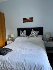 - une chambre avec un grand lit blanc et deux lampes dans l'établissement Beautiful Double Room in Idyllic West End Townhouse, à Glasgow