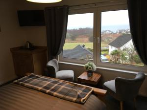 1 dormitorio con cama y ventana grande en Brecbennoch, en Oban