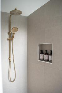 a shower with a shower head in a bathroom at Walton House in Huonville