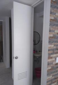 baño con puerta blanca y lavamanos en Casa Agradable con estacionamiento privado, en Santa Marta