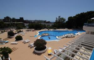 a large swimming pool with lounge chairs and a swimming pool at Everything You Need. All Right Here. in Adeje