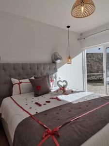 a bedroom with a bed with a red bow on it at Casa do Visconde 