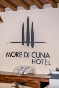 un cartel que lee más dmg cuomo hotel en una pared en Hotel More di Cuna, en Monteroni dʼArbia