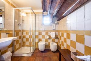 uma casa de banho com 2 WC, um chuveiro e um lavatório. em Hotel More di Cuna em Monteroni dʼArbia