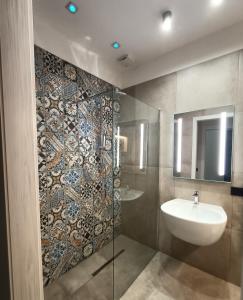 un bagno con lavandino e doccia in vetro di La Sartoria dei Sogni a Lucera Altre 51 foto