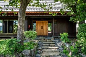 a house with a stone path leading to a wooden door at LiveGRACE House Lake Saiko 西湖古民家 in Yamanashi