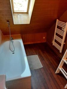 a attic bathroom with a tub and a window at Gite 3 chambres chambres, calme et bien placé in La Forest-Landerneau