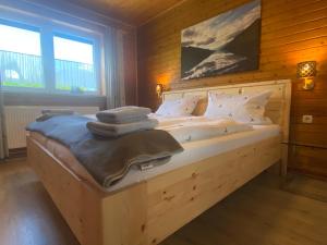 a bedroom with a bed with white sheets and pillows at Das Fex in Aschau