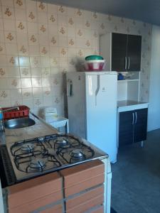een keuken met een fornuis en een koelkast bij Kitnet em Matinhos PR in Matinhos
